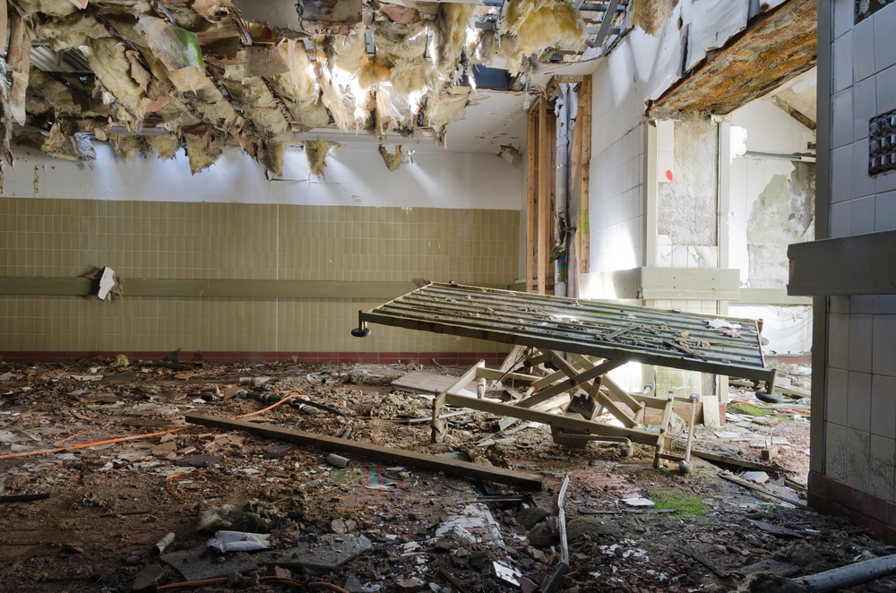 Severe water and fire damage to commercial building interior showing collapsed ceiling and debris before Pinpoint restoration service